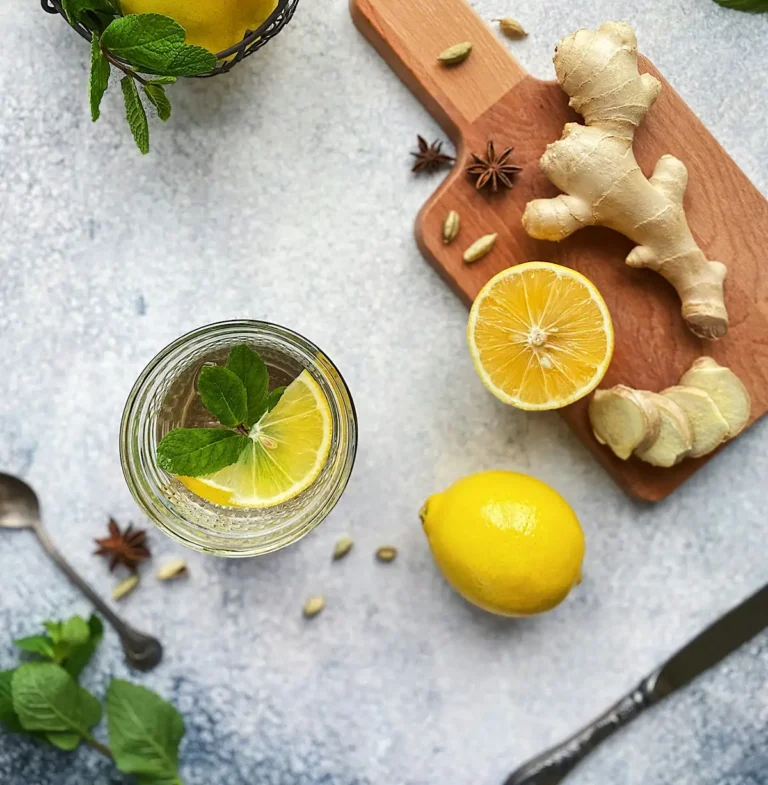 Ingwer Kurkuma Shot – Glas mit goldgelbem Shot, daneben Ingwer, Kurkuma und Zitrone