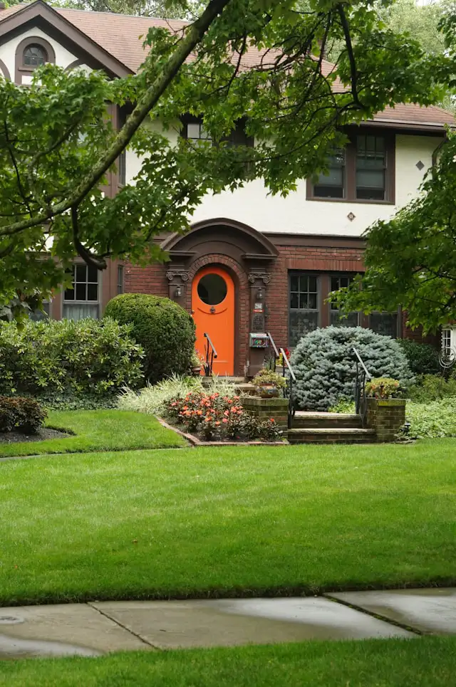Klee aus Rasen entfernen – gepflegter Gartenrasen vor Haus
